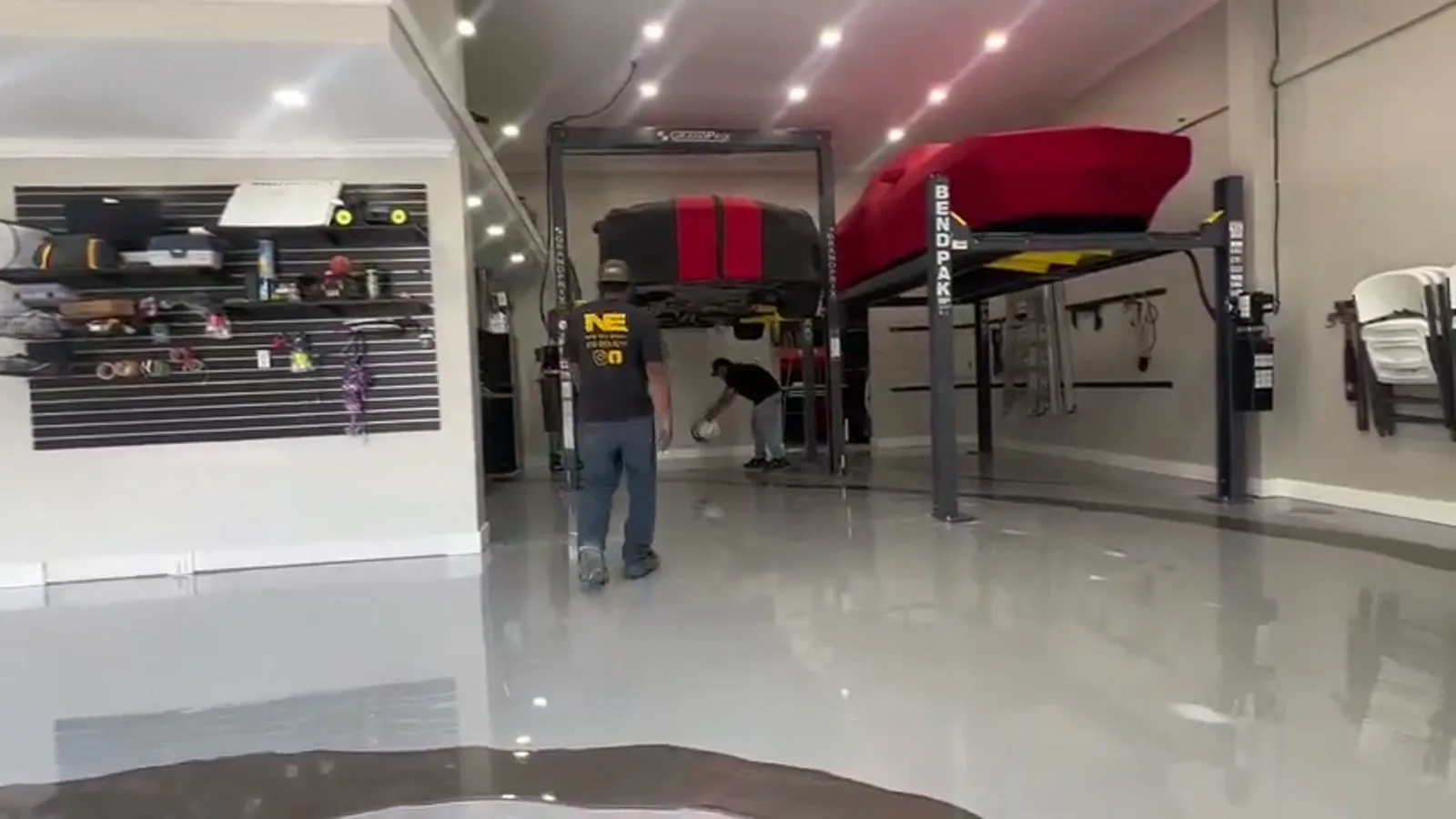 A finished gloss garage floor with a car lift and cabinets