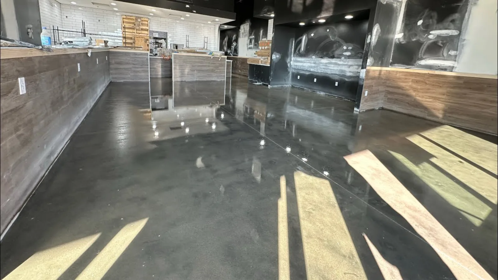 A polished concrete floor reflecting the light in a finished room